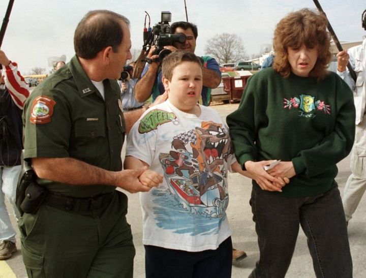 Corey Hallet, a third grader at the Westside Middle School, is escorted by his mother, Holly, and Elvis Poe of the Arkansas Game and Fish Commission, to take part in a program to help students cope with the fatal shootings, March 25, 1998.