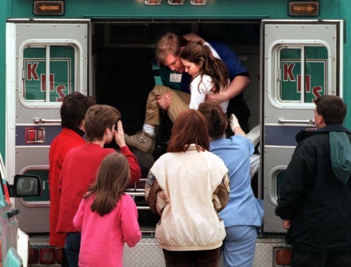 An emergency worker carries a young girl from an ambulance outside Westside Middle School, March 24, 1998.