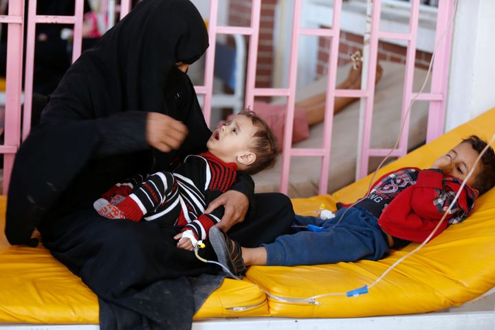 A woman sits with her sons while they are treated at a cholera treatment center in Sanaa, Yemen.