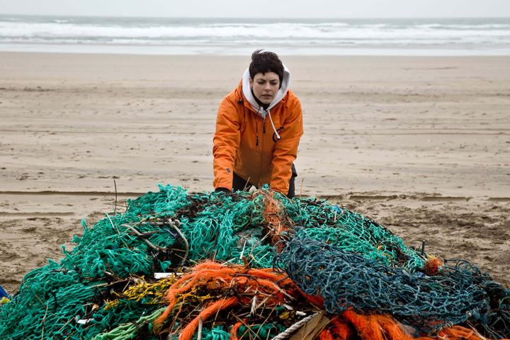 World Animal Protection's Christina Dixon with the heap of debris collected on a beach clean in Cornwall, UK