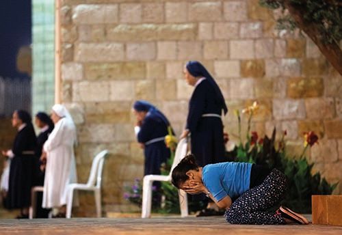 A woman prays alongside Maronite nuns at the Monastery of the Cross in Jal El-Dib north of Beirut (courtesy AFP)