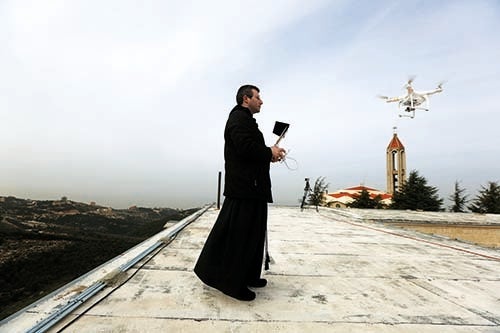 A Maronite priest flies a drone to film and photograph processions and prayers at the Saint Maroun Monastery of Annaya, north of Beirut (courtesy AFP)