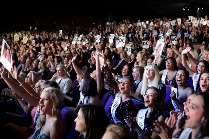 Audience members cheer contestants during the 2010 Miss America pageant.