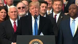 <p>President Trump, surrounded by Republican legislators, celebrating passage of the GOP tax bill.</p>