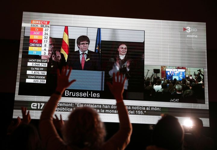 People watch Puigdemont speak on a giant screen in Barcelona