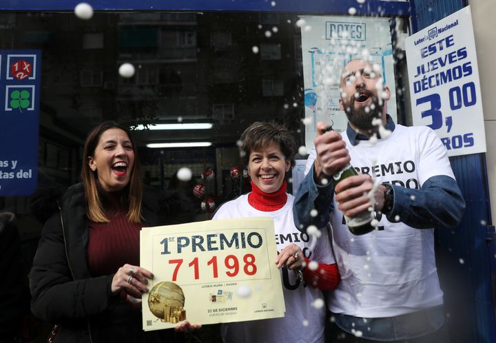 Olivia Muina and her son and daughter, Elena and Javier Castroverde, owners of one of the lottery kiosks that sold the winning number of the biggest prize of Spain's Christmas Lottery, celebrate in Madrid on Friday. 
