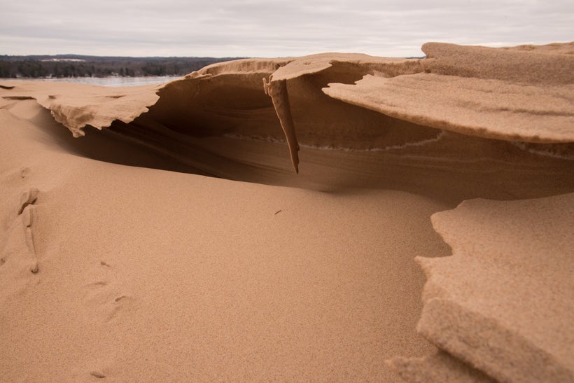 Thin layers of sand, bent into waves on the top of the expansive dunes.