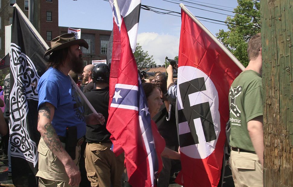 Marchers carry Confederate and Nazi flags during the Unite the Right rally in Charlottesville, Virginia, on Aug. 12, 2017.
