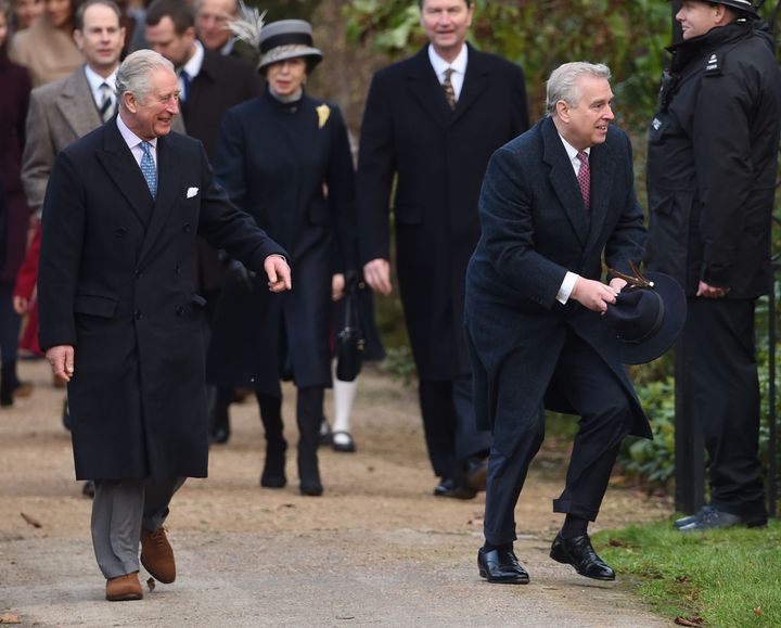 Prince Charles and the Duke of York (right) laugh as a blown away hat is caught just in the nick of time 