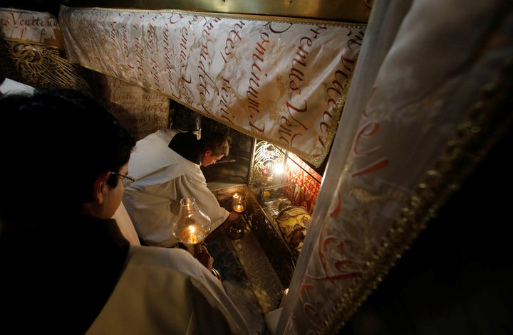 Clergymen attend a Christmas midnight mass at the Church of the Nativity in the West Bank city of Bethlehem on December 25, 2017.