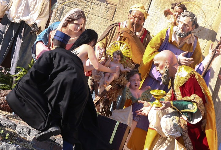 Vatican gendarmes attempt to block a topless activist in St. Peter's Square on Monday before the pope's Christmas address.