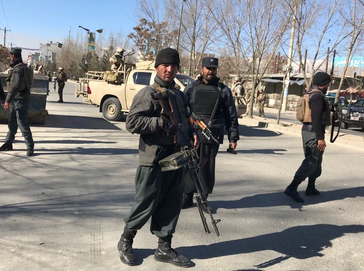 Police officers stand guard at the site of the blast at the Afghan Voice news agency in Kabul.