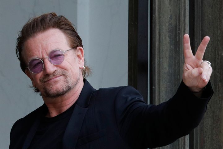 Bono waves as he arrives at the Elysee Palace in Paris, France on July 24. 