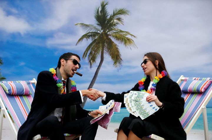 Activists stage a protest on a mock tropical island representing a tax haven.