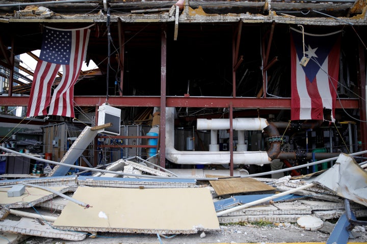 U.S. and Puerto Rico flags hang on a hurricane-damaged church in Carolina, Puerto Rico, on Sept. 26.