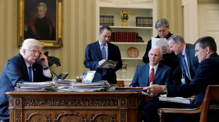 President Donald Trump is joined by Chief of Staff Reince Priebus, center, Vice President Mike Pence, senior adviser Steve Bannon, Communications Director Sean Spicer and national security advisor Michael Flynn as he speaks by phone with Russia's President Vladimir Putin from the Oval Office on Jan. 28.