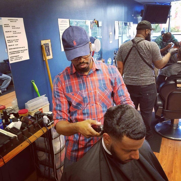 <p>Percy Craig cuts a customer’s hair. </p>
