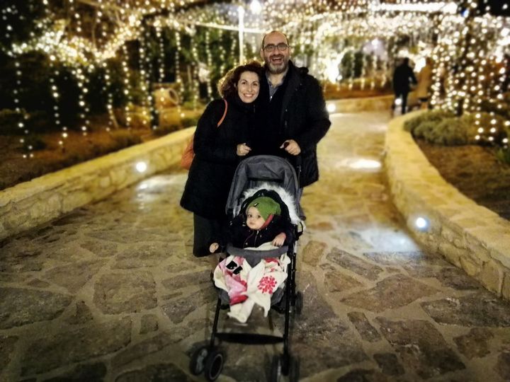 Kalli, Minas, and little Anna-Maria strolling beneath the Christmas lights