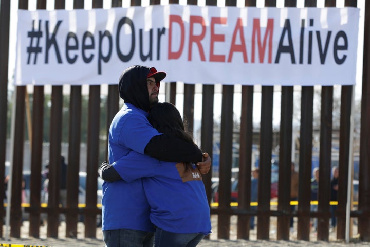 "Dreamers" hug as they meet with relatives during the "Keep Our Dream Alive" binational meeting at a new section of the borde