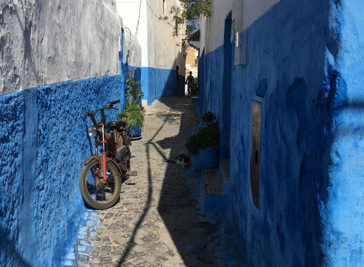 Narrow street with blue walls in Morocco. 