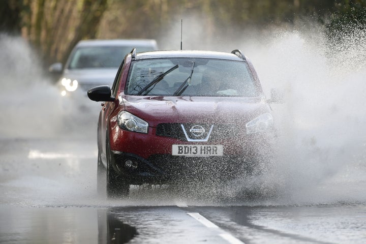 Cars make their way through flood water near Chediston, Suffolk, on Saturday, as Storm Dylan approached