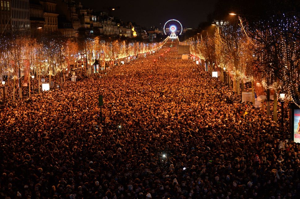 New Year revelers gather on the Champs-Elysees avenue in Paris on December 31, 2017.