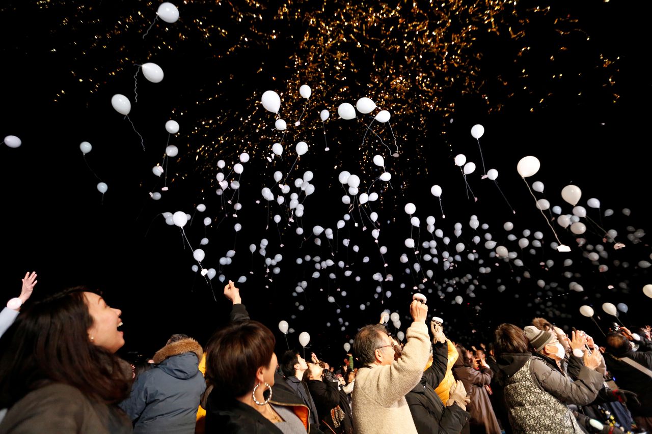 People release balloons as they take part in a New Year's countdown event in Tokyo, Japan on January 1, 2018.