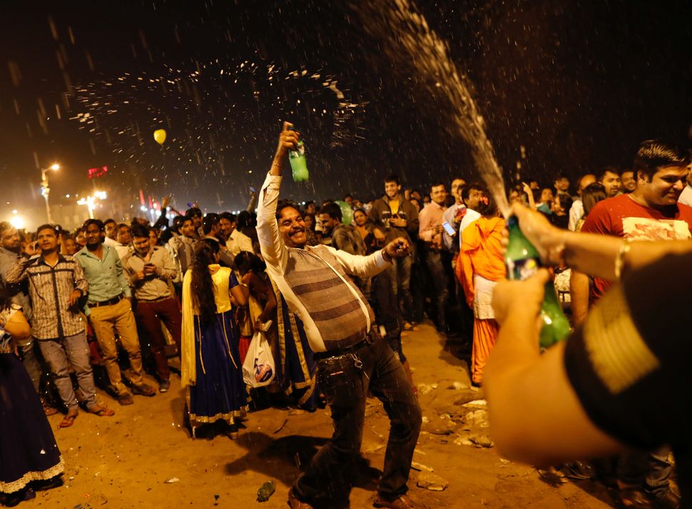 People dance during New Year's celebrations on a beach in Mumbai, India on January 1, 2018.