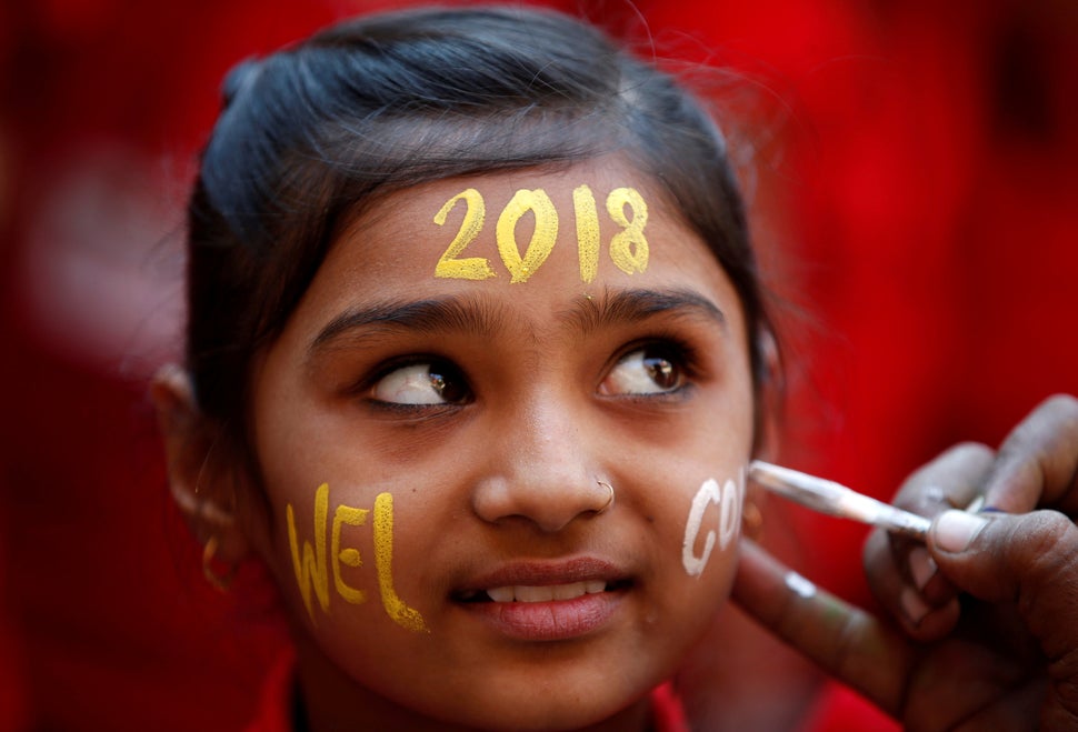 A schoolgirl reacts as she gets her face painted during New Year's celebrations at her school in Ahmedabad, India.