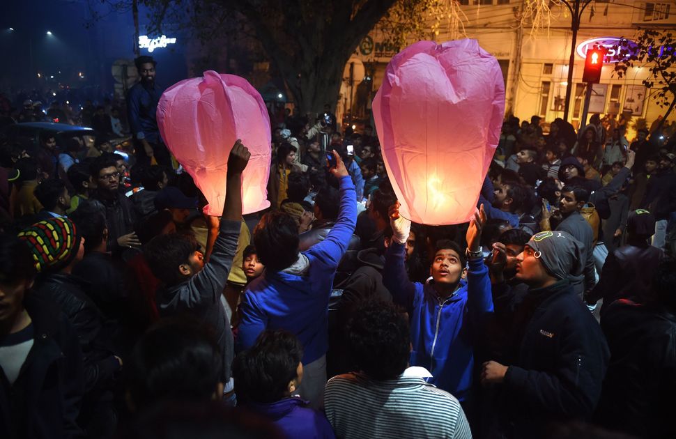 Pakistani people prepare to release lanterns as they gather to celebrate the new year in Lahore on January 1, 2018.