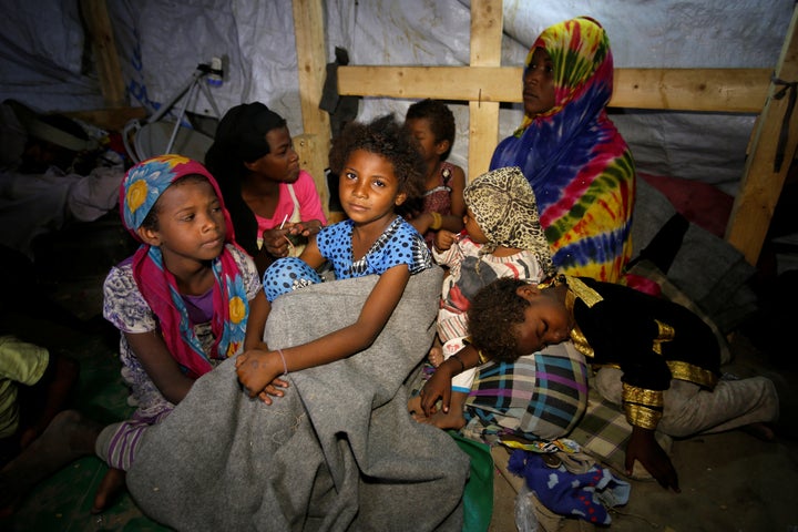 Members of a family displaced by war in the northwestern areas of Yemen sit in their makeshift hut on a street in the Red Sea