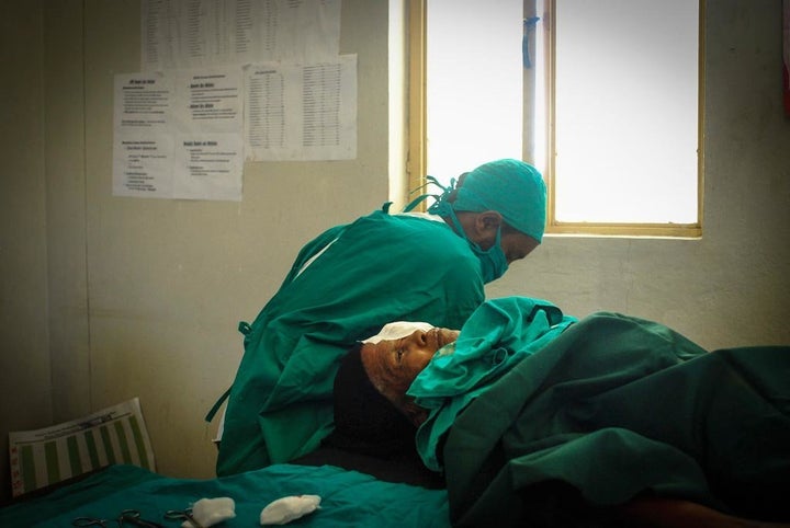 Bugune, still under anaesthetic, lies on the operating table after receiving the simple and cheap eyelid surgery that saved her sight.