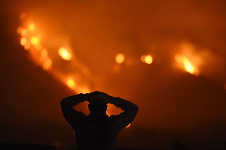A man watches the Thomas fire in the hills above Carpinteria, California, on Dec. 11, 2017.