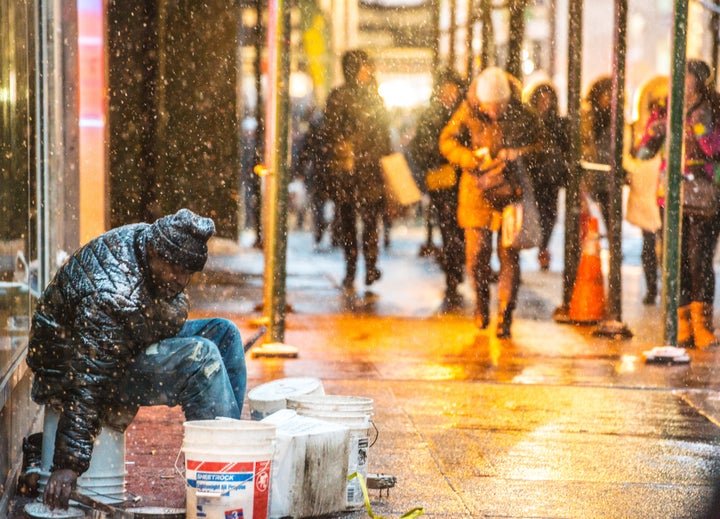 A homeless man sits outside during a snowfall in New York City on Jan. 25, 2014.