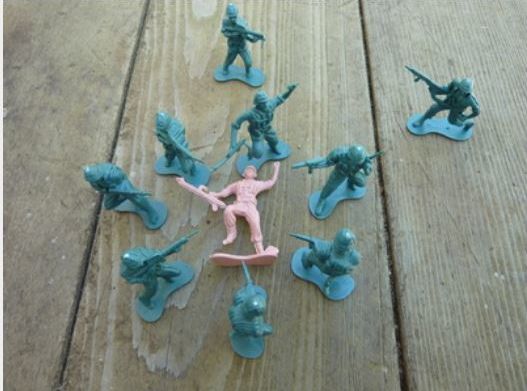 A diorama about a military sexual assault, where the figure in pink is the victim (male, female or transgender) and the green figures are the assailants. The staging of the figures was part of an impromptu discussion with noted MST advocate, Susan Avila-Smith.