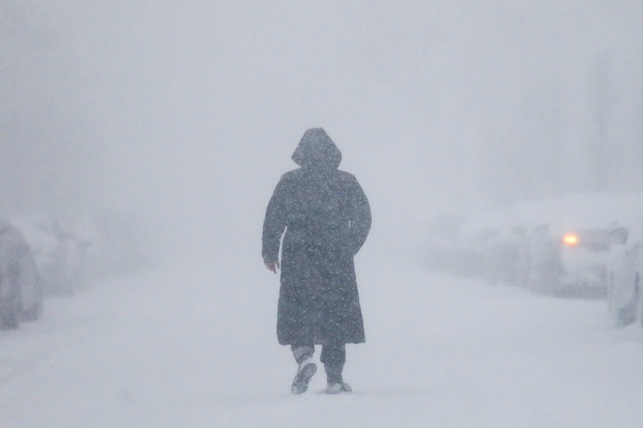 A woman walks down the street during a blizzard in Long Beach, New York. 