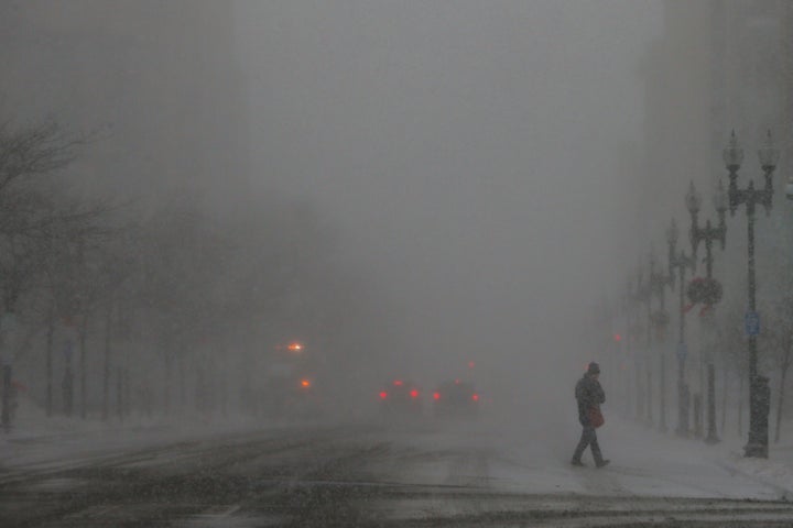 A pedestrian crosses a street during a winter snowstorm in Boston on Thursday.