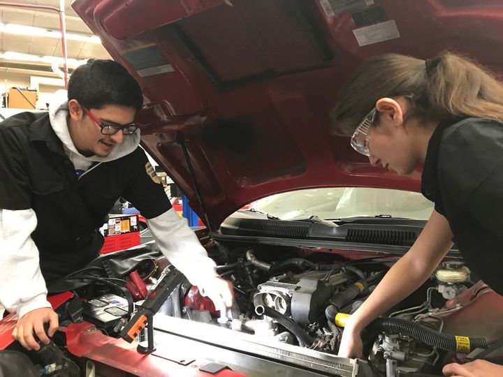 Students at an Eden Area ROP's auto shop class work on a car engine.