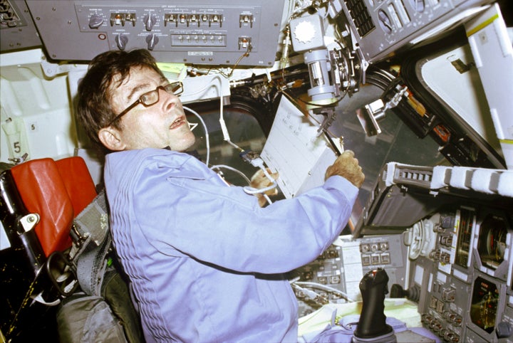 John Young prepares to log flight-pertinent data in a notebook aboard the Space Shuttle Columbia in April 1981.