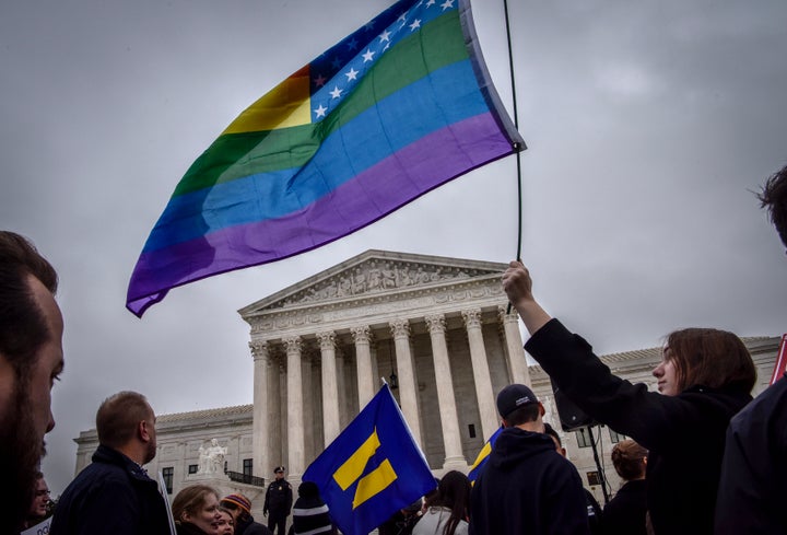 Hannah Flood, an American University student from Maine, holds her rainbow flag high outside the Supreme Court on Dec. 5, 2017.