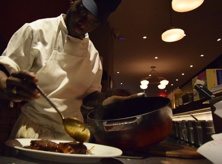 <p>Lamory Sanogo serves up pork ribs Vindaloo at Paowalla</p>