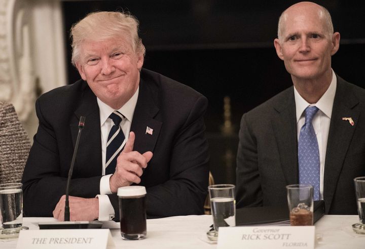 President Donald Trump smiles beside Florida Gov. Rick Scott in June. The president has encouraged Scott to run for the Senate.