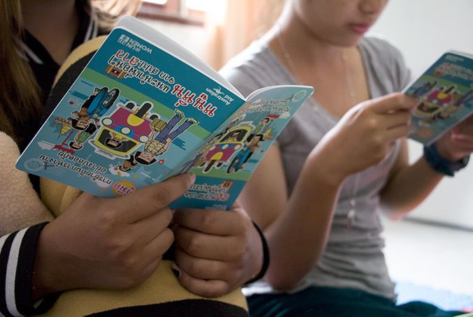 Two young women read the Safe Migration Booklet at the shelter for victims of trafficking in Vientiane, Laos. They had worked at a banana plantation in Thailand. 