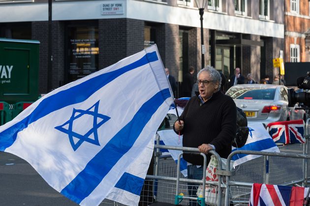 Symbolbild: Ein Mann in London zeigt die Israelflagge.