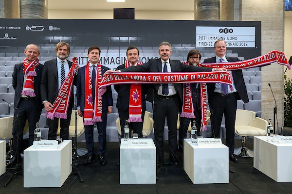The opening ceremony of Pitti Uomo 93 - the speakers holding the giveaway scarf featuring the Museum of Costume and Fashion a