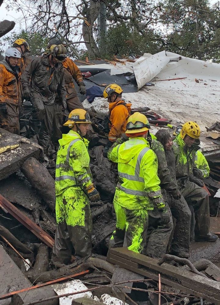 Emergency workers rescue Lauren Cantin, 14, who is covered in mud (r)