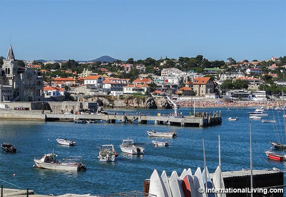 Small beach and boat-filled harbor area near Cascais's cathedral, close-up. Cascais, Portugal.