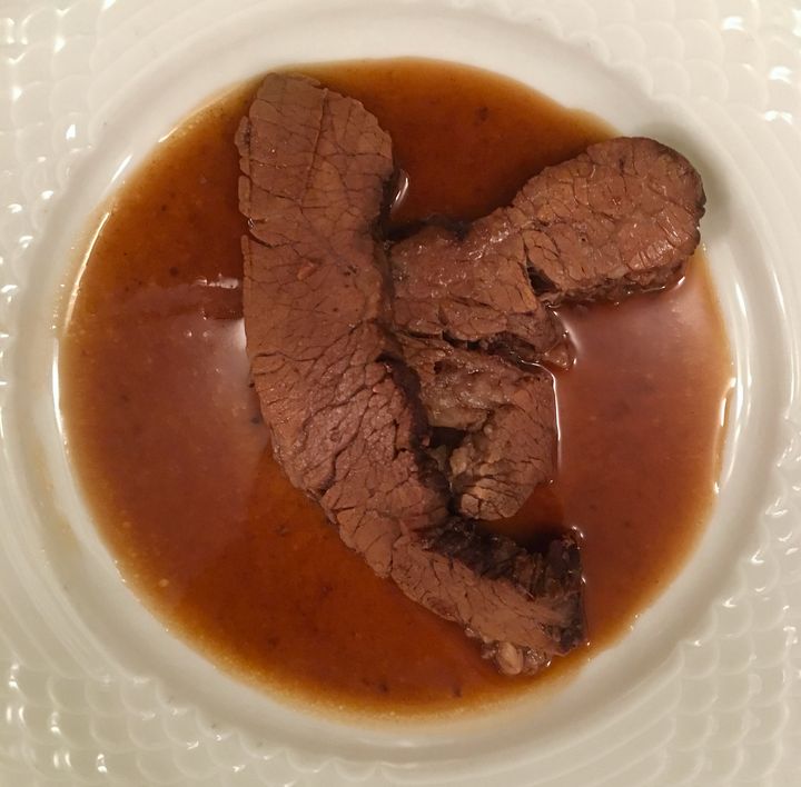 Braised brisket, its rich brown sauce flavored with coffee
