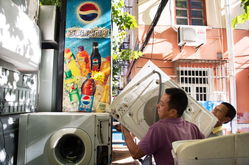 Mr. Wang loads a washing machine onto his truck in Shanghai.