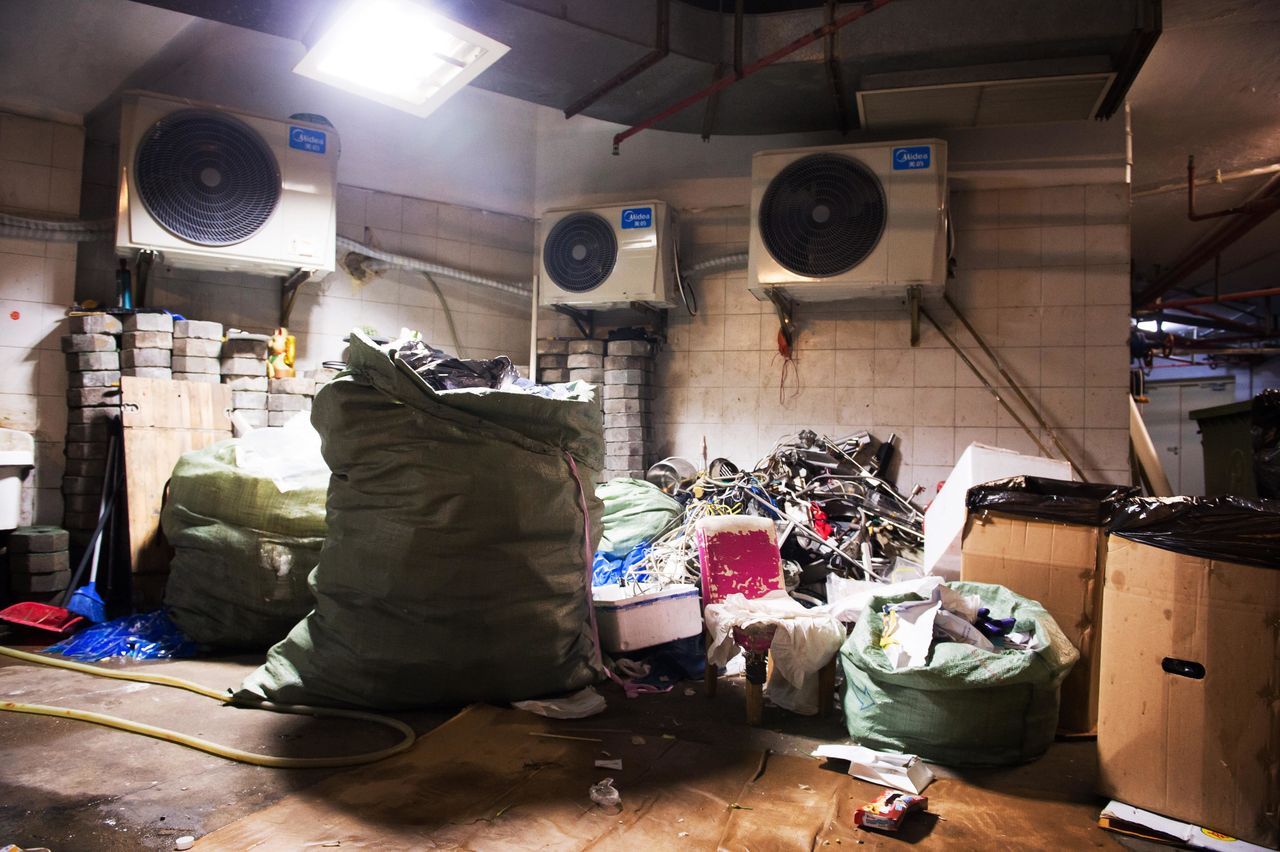 In the basement of a large apartment complex, recyclers sort and stockpile trash -- and live among the detritus.